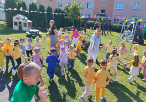 Przedszkolaki ze swoimi paniami podczas zabaw tanecznych w ogrodzie przedszkolnym.