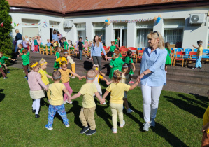 Przedszkolaki ze swoimi paniami podczas zabaw tanecznych w ogrodzie przedszkolnym.