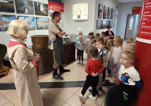 Pan i Pani, prowadzący warsztaty ubrani w starodawne stroje, tłumaczą dzieciom zebranym w holu biblioteki, specyfikę czerpania papieru i starodruku.