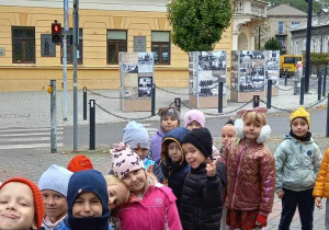 Grupa dzieci ustawionych w parach na tle ratusza miejskiego.