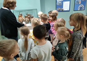 Pani przewodnik opowiada ciekawostki związane z bolesławiecką ceramiką.