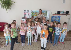 Dzieci stoją w grupie za nimi pani higienistka.