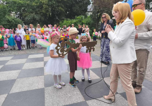 Dwie dziewczynki i chłopiec odbierają Klucz do Miasta od wiceprezydent Radomska.