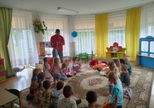 Pan ratownik pokazuje dzieciom sposoby udzielania pierwszej pomocy.
