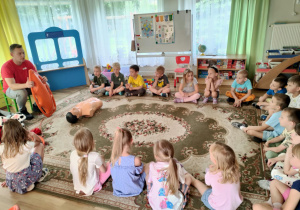 Pan ratownik pokazuje dzieciom sposoby udzielania pierwszej pomocy.
