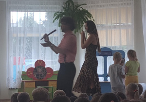 Muzycy prezentują dzieciom gre na flecie.