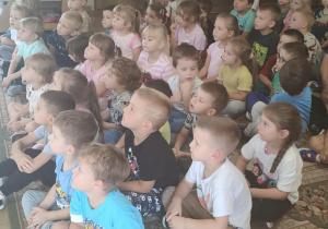 Dzieci w skupieniu słuchają audycji muzycznej.
