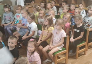 Dzieci w skupieniu słuchają audycji muzycznej.