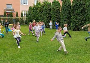 Przedszkolaki podczas zabaw ruchowych na placu przedszkola.