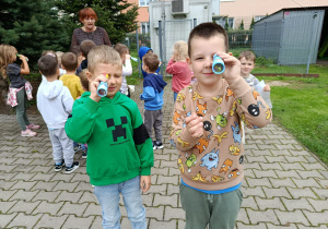 Dwóch chłopców patrzy w mozaikowe lornetki.