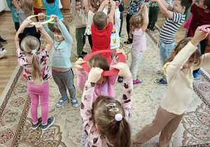 Dzieci trzymają kółko serso w parach nad głowami.