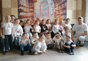 Grupa Promyczków na wspólnym zdjęciu z pracownikami piekarni.