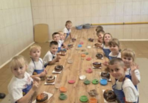 Dzieci ozdabiaja swoje pączki.