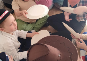 Zabawa z talerzykami służącymi jako wachlarze do rozdmuchiwania kolorowej, pociętej drobno bibuły.