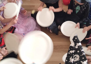 Zabawa z talerzykami służącymi jako wachlarze do rozdmuchiwania kolorowej, pociętej drobno bibuły.