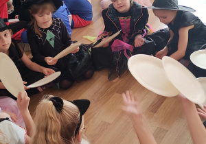 Zabawa z talerzykami służącymi jako wachlarze do rozdmuchiwania kolorowej, pociętej drobno bibuły.