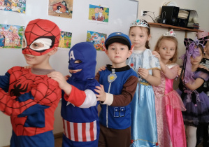 Dzieci w przebraniach tańczą tworząc korowód.