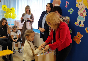 Julia z grupy Słoneczka otrzymuje z rąk pani wiceprezydent dyplom i nagrodę.