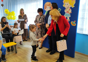 Julcia z grupy Jagódki otrzymuje z rąk pani wiceprezydent dyplom i nagrodę.