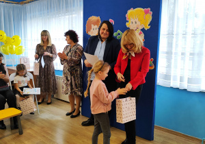 Amelka z grupy Promyczki otrzymuje z rąk pani wiceprezydent dyplom i nagrodę.