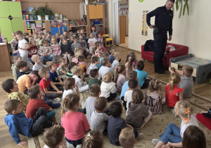 Policjant wskazuje na kaburę, w której nosi broń.