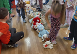 Dzieci ustawiają swoje misie jeden przed drugim.