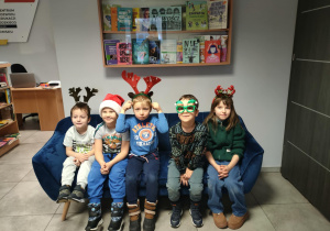 Motylki na kanapie w świątecznych opaskach pozują do zdjęć.