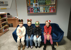 Motylki na kanapie w świątecznych opaskach pozują do zdjęć.