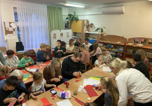 Rodzice i dzieci podczas tworzenia ozdób świątecznych.