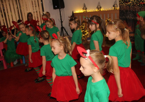 Dziewczynki tańczą swój taniec dla Mikołaja.