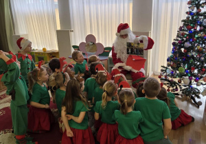 Mikołaj wręcza Motylkom bilet do Fabryki Bombek.