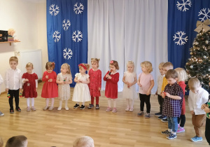 Maluszki śpiewają kolędę i grają na dzoneczkach i marakasach.