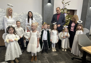 Uczestnicy wspólnego kolędowania stoją do zdjęcia.