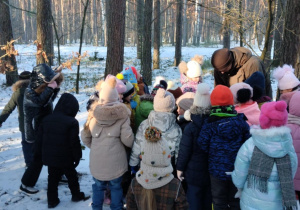 Przedszkolaki uważnie słuchają tego, o czym opowiada im pan Leśnik.