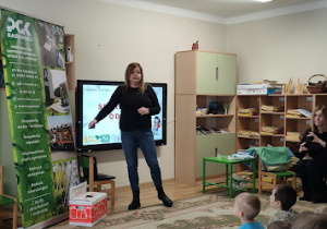 Przedstawicielka PGK-u prowadzi pogawędkę z dziećmi na temat sortowania śmieci.