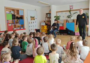 Pan Witek wita się z przedszkolakami i przedstawia swojego gościa grającego na wiolonczeli.