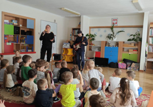 Dzieci bawią się przy dźwiękach gitary basowej.