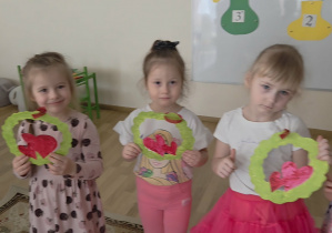 Dziewczynki trzymają w rączkach laurki otrzymane od chłopaków.