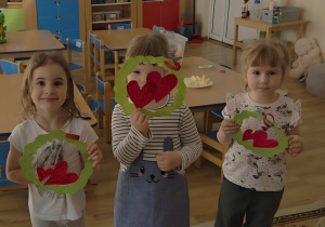 Dziewczynki trzymają w rączkach laurki otrzymane od chłopaków.