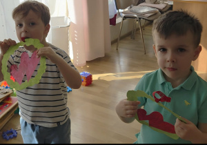 Chłopcy trzymają w rączkach laurki dla dziewczynek.