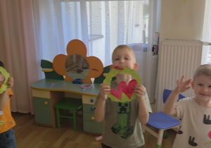 Chłopcy trzymają w rączkach laurki dla dziewczynek.