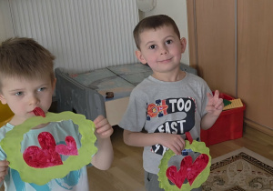 Chłopcy trzymają w rączkach laurki dla dziewczynek.