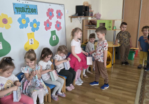 Chłopcy częstują dziewczynki cukierkami.