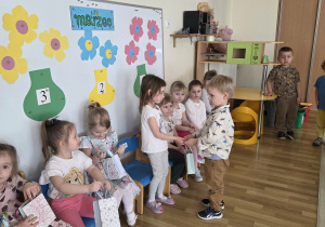 Chłopcy częstują dziewczynki cukierkami.