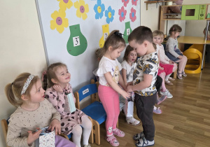 Chłopcy częstują dziewczynki cukierkami.