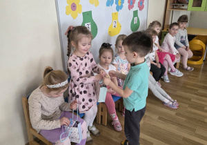 Chłopcy częstują dziewczynki cukierkami.