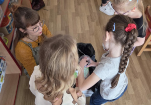 Sadzenie bratków przy stoliczkach pod nadzorem prowadzących warsztaty.