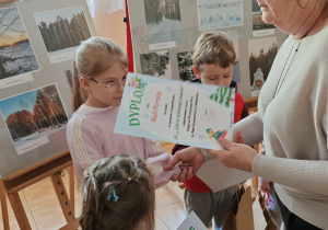 Nela otrzymuje dyplom i nagrodę.