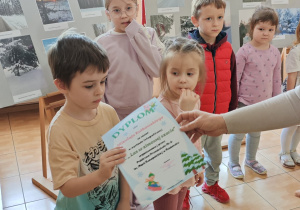 Lenka otrzymuje dyplom i nagrodę.