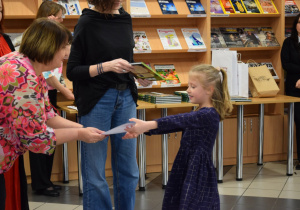 Tosia odbiera dyplom i książkę.